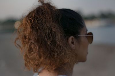 Close-up of young woman against sea