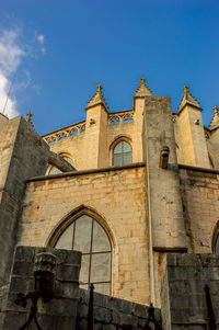 Low angle view of old building against blue sky