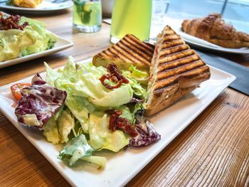 Sandwich and salad in tray on table at restaurant