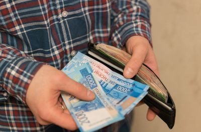 Midsection of man removing paper currencies from wallet