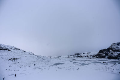 Scenic view of snow covered mountains against clear sky