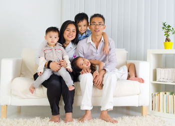 Portrait of happy family sitting on sofa at home