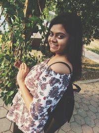 Portrait of smiling young woman standing outdoors