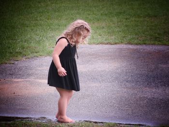 Full length of young woman standing in grass