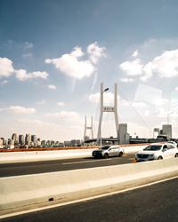 Cars on street against sky