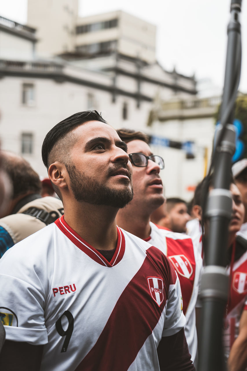 real people, focus on foreground, architecture, people, incidental people, day, young men, adult, building exterior, men, young adult, waist up, mid adult men, built structure, mid adult, city, portrait, group of people, looking, outdoors