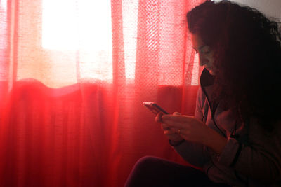 Midsection of woman using mobile phone at home