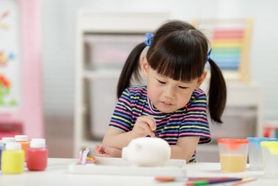 Rear view of girl at table at home
