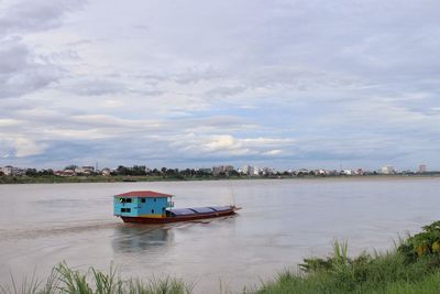 Boat in river against sky