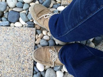 Low section of woman standing on pebbles