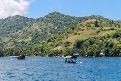 Scenic view of lake amidst trees and mountains against sky