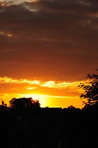 Silhouette city against sky during sunset