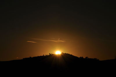 Scenic view of silhouette field against sky during sunset