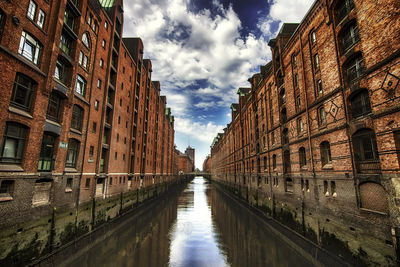 Canal amidst buildings against sky