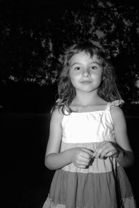 Portrait of cute girl standing against wall