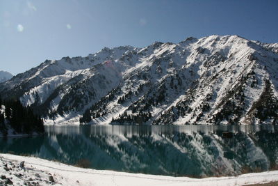 Scenic view of lake and snowcapped mountains against sky