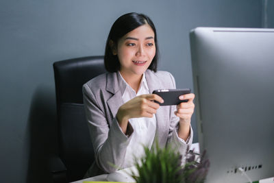 Portrait of a smiling young woman using phone