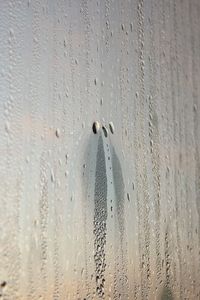 Drops in melting ice on a window forming a pattern