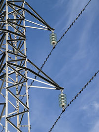 Low angle view of cranes against sky