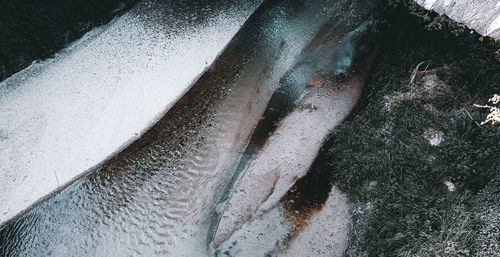 High angle view of person standing on wet snow