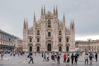 Crowd at milan cathedral against sky