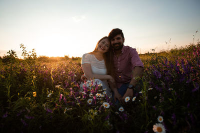 Young couple on field against sky