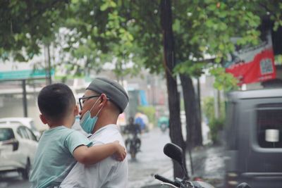 Rear view of father and son on road