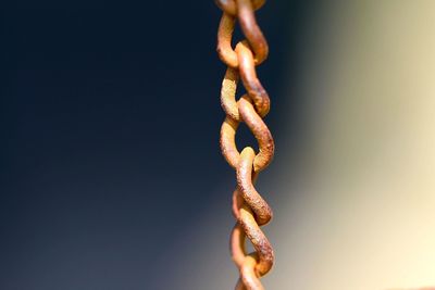 Close-up of metal chain against clear sky