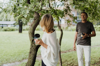 Side view of couple standing against trees