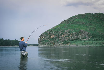 The fisher on the mountain river colored