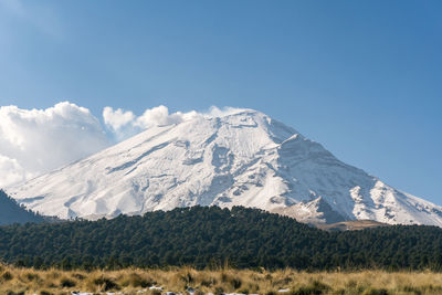 Scenic view of snowcapped mountains against clear blue sky