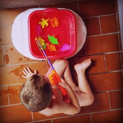 Directly above shot of boy playing with fishing game in bathroom
