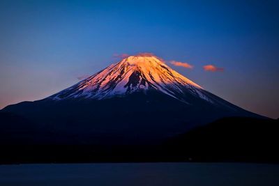 Scenic view of mountains against blue sky