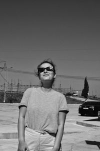 Young man wearing sunglasses standing against clear sky