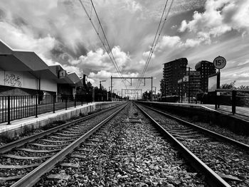 Railroad tracks amidst buildings against sky