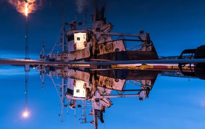 Reflection of old ship in sea moored at harbor during night