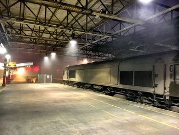 Illuminated railroad station platform at night