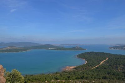 Scenic view of sea and mountains against blue sky