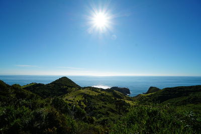 Scenic view of sea against bright sun