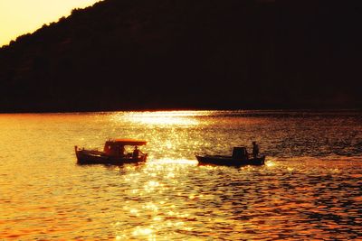 Silhouette boat sailing on sea against sky at night