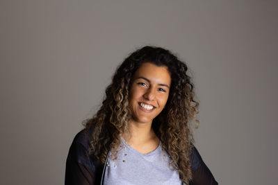 Portrait of smiling girl against gray background