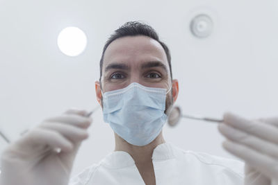 Portrait of doctor holding medical equipment in operating room