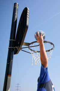 Low angle view of basketball hoop against clear blue sky