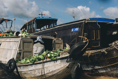 View of old boat moored in water against sky