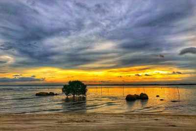 Scenic view of sea against dramatic sky during sunset