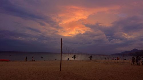 Silhouette of people on beach at sunset