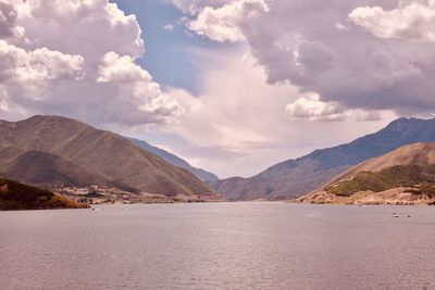 Scenic view of sea and mountains against sky