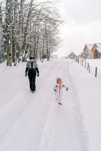 People skiing on snow covered landscape