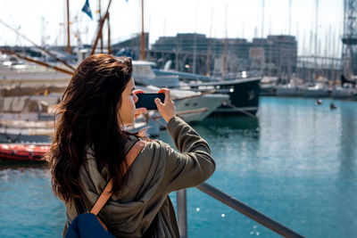 Woman photographing with mobile phone in city