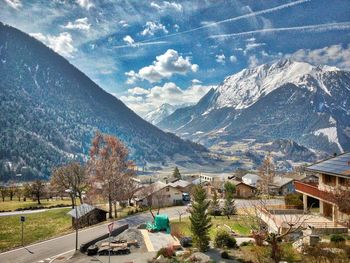 Aerial view of townscape and mountains against sky